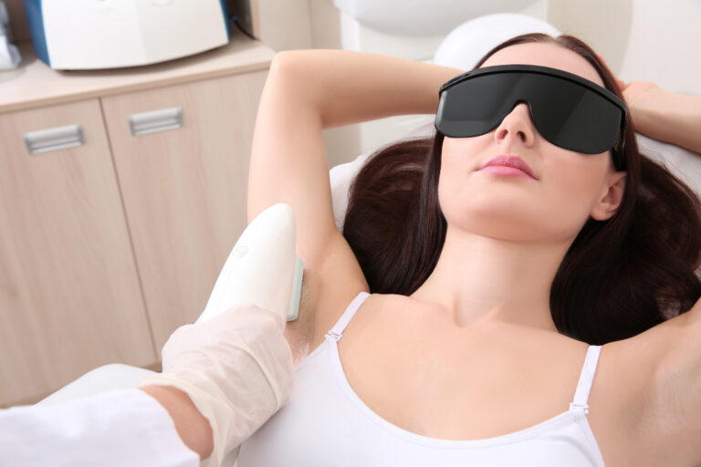 Beautiful woman getting laser epilation in beauty salon