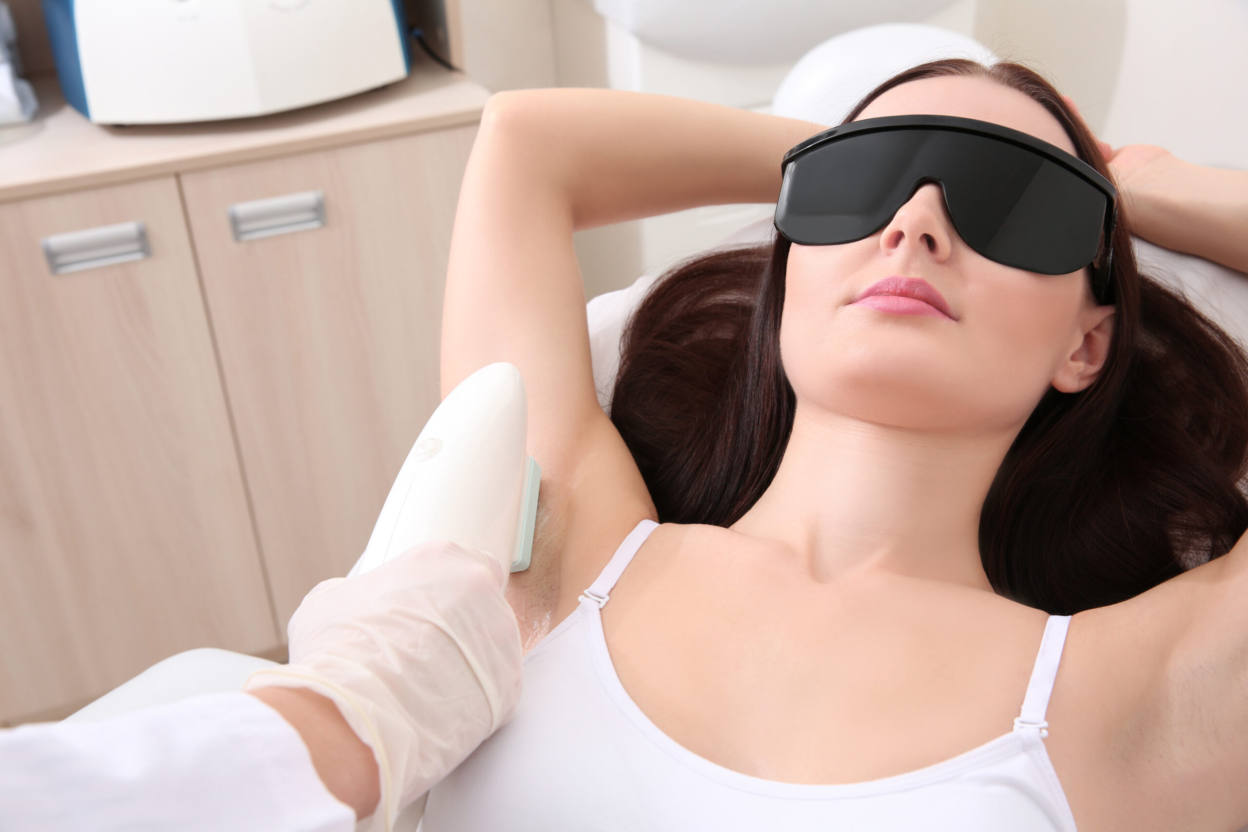 Beautiful woman getting laser epilation in beauty salon